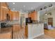 Open kitchen with wood cabinets and breakfast bar flowing into the living area at 300 Williamston Ridge Dr, Youngsville, NC 27596