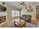 Comfortable living room featuring hardwood floors, fireplace, TV, and large windows at 300 Williamston Ridge Dr, Youngsville, NC 27596