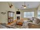 Cozy living room with fireplace, ceiling fan, hardwood floors, and comfortable gray sofas at 300 Williamston Ridge Dr, Youngsville, NC 27596