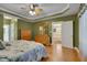 Spacious main bedroom showing hardwood floors, ceiling fan, dresser, and entry to the ensuite bathroom at 300 Williamston Ridge Dr, Youngsville, NC 27596