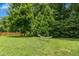 Lush backyard featuring mature trees, a hammock, and plenty of space at 304 Forbes Rd, Wake Forest, NC 27587