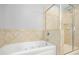 Elegant bathroom with a jacuzzi-style tub and a glass-enclosed shower at 304 Forbes Rd, Wake Forest, NC 27587