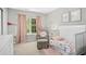 Charming Bedroom with pink accents, a crib, and a comfortable armchair at 304 Forbes Rd, Wake Forest, NC 27587