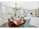 Light-filled dining room featuring a chandelier, hardwood floors, and views into the adjacent living area for seamless flow at 304 Forbes Rd, Wake Forest, NC 27587