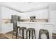 Bright kitchen with white cabinets, stainless steel appliances, and a breakfast bar with seating for casual dining at 304 Forbes Rd, Wake Forest, NC 27587