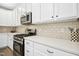 Modern kitchen with stainless steel appliances, white cabinets, subway tile backsplash, and ample counter space for meal preparation at 304 Forbes Rd, Wake Forest, NC 27587
