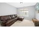 Comfortable living room featuring a plush leather couch and ample natural light at 304 Forbes Rd, Wake Forest, NC 27587
