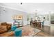 Open-concept living space with hardwood floors, a colorful rug, comfortable seating, and ample natural light from large windows at 304 Forbes Rd, Wake Forest, NC 27587