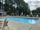 Large community swimming pool with lounge chairs and tables, providing a great place for relaxation and socializing at 3045 Creek Moss Ave, Wake Forest, NC 27587