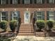 Close up of a traditional brick home with a white front door and brick steps leading to the entrance at 3045 Creek Moss Ave, Wake Forest, NC 27587