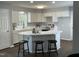 Bright kitchen with white cabinets, stainless steel appliances, a peninsula island and a view into the living room at 3045 Creek Moss Ave, Wake Forest, NC 27587