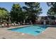 Community swimming pool surrounded by lounge chairs and umbrellas with a nearby changing area under a clear blue sky at 3045 Creek Moss Ave, Wake Forest, NC 27587