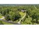 Aerial view of a home surrounded by trees and open space along a long gravel driveway at 3113 Golden Nugget Dr, Clayton, NC 27520