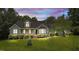 Inviting exterior featuring dormers, a bay window, and a covered porch, all surrounded by lush greenery at 3113 Golden Nugget Dr, Clayton, NC 27520