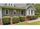 Charming front porch features wood railing, complemented by manicured hedges and lush green lawn at 3113 Golden Nugget Dr, Clayton, NC 27520
