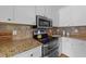 Kitchen showcasing granite countertops, stainless steel microwave, and tile backsplash at 3113 Golden Nugget Dr, Clayton, NC 27520