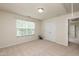 Bright bedroom with neutral carpet, double doors, and a large window overlooking trees at 3445 Dutchman Rd, Raleigh, NC 27610