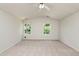 Spacious carpeted bedroom with abundant natural light from two windows and a ceiling fan overhead at 3445 Dutchman Rd, Raleigh, NC 27610