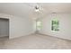 Bright carpeted bedroom with two large windows, a ceiling fan, and a doorway to other rooms at 3445 Dutchman Rd, Raleigh, NC 27610