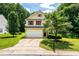 Inviting two-story home with an attached garage, surrounded by mature trees and a green lawn at 3445 Dutchman Rd, Raleigh, NC 27610