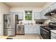Well-lit kitchen with stainless steel appliances, blue cabinets, and a window view at 3445 Dutchman Rd, Raleigh, NC 27610