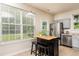 Bright kitchen with a stainless steel refrigerator, island seating, and backyard access at 3445 Dutchman Rd, Raleigh, NC 27610