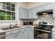 Efficient kitchen layout with stainless steel appliances, blue cabinets, and ample natural light at 3445 Dutchman Rd, Raleigh, NC 27610
