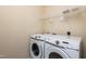 Modern laundry room with front-loading washer and dryer and shelving unit at 3445 Dutchman Rd, Raleigh, NC 27610