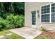 Back patio with access to the home, surrounded by lush landscaping at 3445 Dutchman Rd, Raleigh, NC 27610