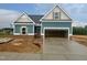 New construction home featuring teal siding, brick accents and two car garage with newly poured concrete driveway at 360 Ambassador Dr, Clayton, NC 27520