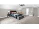 Spacious carpeted bedroom featuring neutral walls, ceiling fan, a king bed, and an upholstered storage bench at 3604 Thorndike Dr, Wake Forest, NC 27587