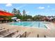 Large community pool with lounge chairs, umbrellas, and a slide, providing a perfect spot for relaxation and fun at 3604 Thorndike Dr, Wake Forest, NC 27587