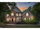 Charming two-story brick home with warm lighting, showcasing its inviting facade and landscaped front yard at 3604 Thorndike Dr, Wake Forest, NC 27587