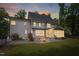 Charming home exterior at dusk, highlighting the backyard patio, screened porch, and well-lit windows at 3604 Thorndike Dr, Wake Forest, NC 27587