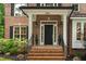 Inviting entryway featuring brick steps, a black front door, and elegant exterior lighting at 3604 Thorndike Dr, Wake Forest, NC 27587