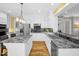 Bright kitchen with white cabinets, stainless steel appliances, granite countertops, and hardwood floors at 3604 Thorndike Dr, Wake Forest, NC 27587