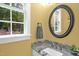 Bathroom showcasing granite countertop, round mirror, neutral paint and a backyard view at 3604 Thorndike Dr, Wake Forest, NC 27587