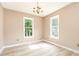 Light-filled bedroom with hardwood floors and two large windows offering serene outdoor views at 3605 Iron Sight Ct, Raleigh, NC 27616