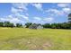 A single-story gray home on a large, well-kept lawn with blue sky and scattered clouds above at 3724 Stevens Chapel Rd, Smithfield, NC 27577