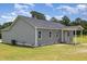 Side view of a gray home with vinyl siding, a covered patio, and a well-maintained lawn at 3724 Stevens Chapel Rd, Smithfield, NC 27577