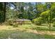A sprawling backyard featuring a deck, wooden gazebo, and lush greenery, surrounded by tall trees at 420 Lipscomb Grove Church Rd, Hillsborough, NC 27278