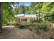 Charming yellow home with a wooden deck and lush landscaping surrounded by mature trees at 420 Lipscomb Grove Church Rd, Hillsborough, NC 27278