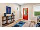A stylish foyer with wood floors, a colorful rug, a red door, and decorative shelving unit at 426 Granite Mill Blvd, Chapel Hill, NC 27516