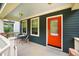 Inviting front porch with seating, white railings, blue siding, and a vibrant red door at 426 Granite Mill Blvd, Chapel Hill, NC 27516