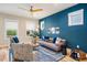 Stylish living room featuring modern decor, wood floors, a bold blue accent wall and an eye-catching ceiling fan at 426 Granite Mill Blvd, Chapel Hill, NC 27516