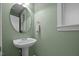Powder room features a pedestal sink, round mirror, and decorative towel ring at 4511 Crab Creek Dr # 101, Raleigh, NC 27612
