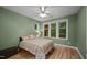 Cozy bedroom featuring wood floors, a ceiling fan, and a sunny window view at 4511 Crab Creek Dr # 101, Raleigh, NC 27612