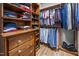 Walk-in closet with built-in wooden shelves, rods, and drawers for optimal storage at 4511 Crab Creek Dr # 101, Raleigh, NC 27612