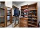 Walk-in closet with built-in wooden shelves, rods, drawers, and a mirrored door at 4511 Crab Creek Dr # 101, Raleigh, NC 27612