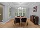 Dining room features tray ceiling, modern chandelier, wood floors, and large windows with shutters at 4511 Crab Creek Dr # 101, Raleigh, NC 27612